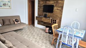 ein Wohnzimmer mit einer Couch und einem Tisch und Stühlen in der Unterkunft Verdadeiro Pé na Areia in Santos