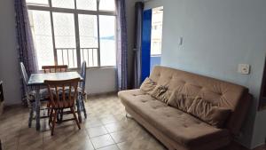 ein Wohnzimmer mit Sofa und Tisch in der Unterkunft Verdadeiro Pé na Areia in Santos