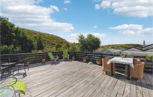 a wooden deck with chairs and a table on it at Three-Bedroom Holiday Home In Knebel in Knebel