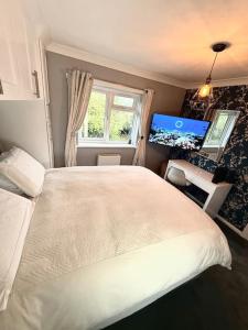 a bedroom with a white bed and a window at Three bedroom house in Harlow +48 photos