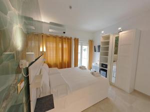 Un dormitorio blanco con una cama y un televisor. en Perfect! Vatican Location, en Roma