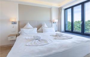 a white bed with two towels on top of it at Prince in Binz