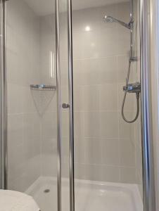 a bathroom with a shower with a glass door at Cartref Guesthouse - Room 2 Ensuite in Aberdyfi