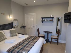 a bedroom with a bed and a desk and a television at Cartref Guesthouse - Room 2 Ensuite in Aberdyfi