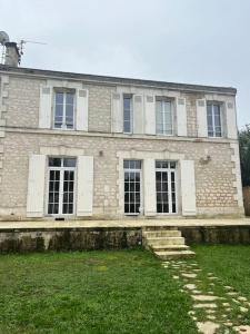 an old brick building with windows and grass in front at Maison 6pers-Centre ville-Jardin in Angoulême