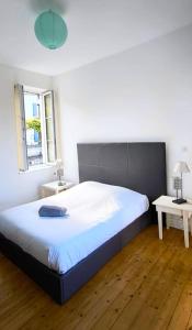a bedroom with a large bed and two tables at Maison 6pers-Centre ville-Jardin in Angoulême