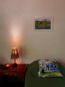 a bedroom with a bed and a lamp on a table at Pousada Terra Caraiva in Caraíva +38 photos