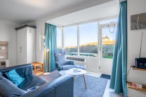 una sala de estar con un sofá y una mesa en Appartementencomplex Juliana 68, en De Koog