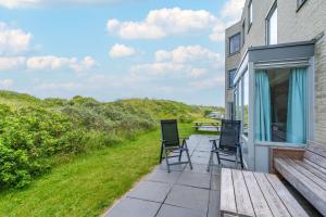 a patio with chairs and a table on the side of a house at Appartementencomplex Juliana 68 in De Koog