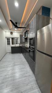 a kitchen with stainless steel appliances and a ceiling fan at Heston Villa Islamabad International Airport in Islamabad