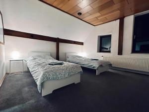 a bedroom with two beds and a table and two windows at sleepWELL-Steinfurt III Familienfreundlich & Zentral in Steinfurt