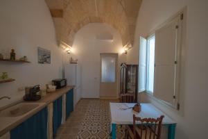 a kitchen with a sink and a table in a room at San Domenico Suite Cavallino in Cavallino di Lecce