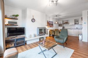 a living room with a tv and a couch and a table at Appartementencomplex Juliana 166 in De Koog