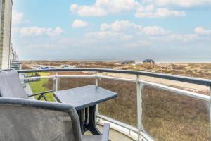 a table on a balcony with a view of the beach at Appartementencomplex Juliana 166 in De Koog