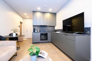 Il comprend un salon avec une grande cuisine et une télévision. dans l'établissement Apartment w-Terrace I Air Condition I New building I Self Check-In, à Birštonas 34 autres photos