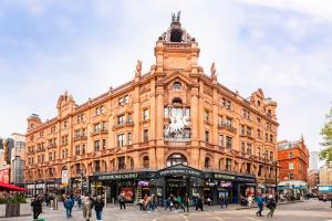 a large building with a clock tower on a street at Welcome London Leicester Square in London