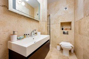 a bathroom with a white sink and a toilet at Welcome London Leicester Square in London +38 photos