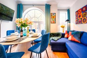 a living room with a blue couch and a table at Welcome London Leicester Square in London