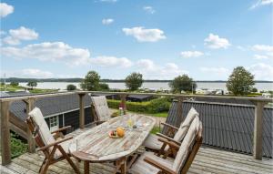 a table and chairs on a deck with a view of the water at Awesome Home In Mariager With Wifi in Mariager
