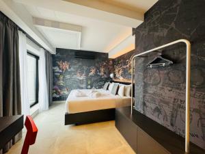 a bedroom with a bed and a wall covered in wallpaper at SO City Hotel Adults Only in St. Julianʼs