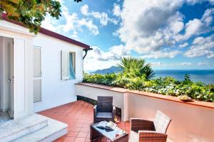 a balcony with chairs and a view of the ocean at Gocce Di Capri Resort in Massa Lubrense