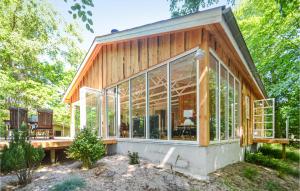 ein Holzhaus mit Glasfenstern und einer Bank in der Unterkunft Nice Home In Glesborg With Wifi in Glesborg