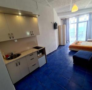a kitchen with a sink and a bed in a room at Malibu Apartments in Sutomore