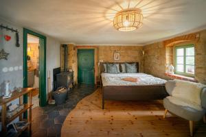 una camera da letto con un letto, una sedia e un lampadario di ENJOY Cozy Romance Hills Forest Gardens Views Sauna Whirlpool Bath a Jablonné v Podještědí