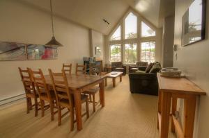 ein Wohnzimmer mit einem Holztisch und Stühlen in der Unterkunft Waters Edge Shoreside Suites in Ucluelet