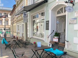 a group of tables and chairs outside of a building at Business-Apartments im SCHUSTER-ACHT in Wolgast