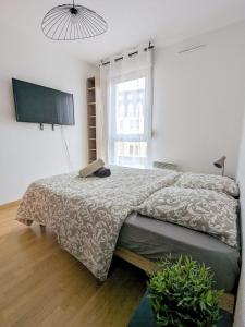a bedroom with a bed and a flat screen tv at Le Clairvaux - Proche centre avec 1 place en parking souterrain in Dijon
