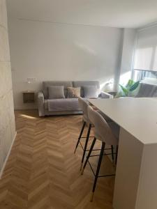Una sala de estar con un sofá, una mesa y sillas. en Luxury Gran Vía centro Murcia, en Murcia