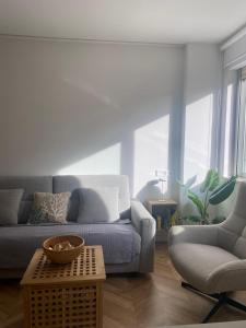 una sala de estar con un sofá y una silla en Luxury Gran Vía centro Murcia, en Murcia