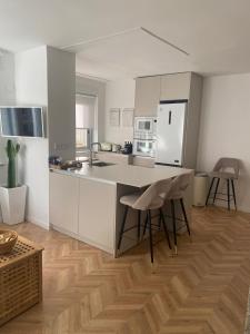 Una cocina con gabinetes blancos y una mesa y sillas. en Luxury Gran Vía centro Murcia, en Murcia