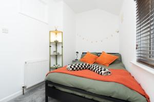 a bedroom with a bed with orange and black pillows at Central 1 Bedroom Home, Free Parking, Sleeps 4, near University in Portsmouth