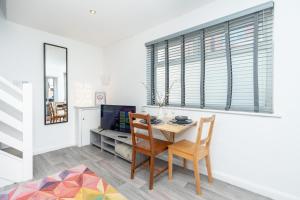 a dining room with a table and chairs and a television at Central 1 Bedroom Home, Free Parking, Sleeps 4, near University in Portsmouth