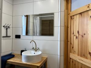 a white bathroom with a sink and a mirror at Domki nad rzeką- Smerekowiec in Smerekowiec +30 photos