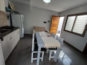 een keuken met een tafel, stoelen en een koelkast bij Departamentos Corazón in San Rafael +36 foto's