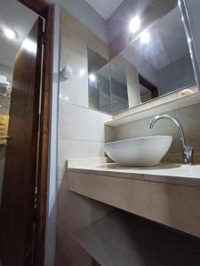 een badkamer met een witte wastafel en een spiegel bij Departamentos Corazón in San Rafael