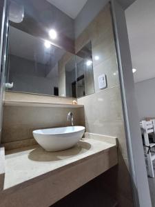 een badkamer met een witte wastafel op een aanrecht bij Departamentos Corazón in San Rafael