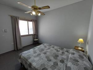 een slaapkamer met een bed en een plafondventilator bij Departamentos Corazón in San Rafael