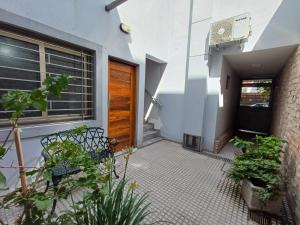 een huis met een deur en een binnenplaats met planten bij Departamentos Corazón in San Rafael