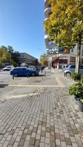 a parking lot with a blue car parked in front of a building at 70 steps studio A, 50 meters from Dimokratias metro station in Thessaloniki