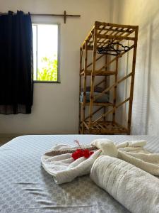 a bedroom with a bed with towels on it at Pousada Éden Rio in Ilhéus