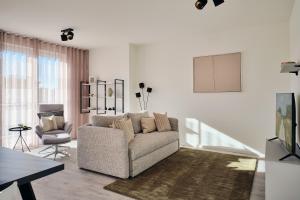 a living room with a couch and a chair at Apartment A13 "Balkon, 2 Schlafzimmer & 2 Bäder inklusive Nutzung der Wellness- und Aktivbereiche" im "Pine Hill Resort" in Zirchow