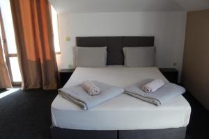 un letto in una camera con due cuscini sopra di Hotel Color a Asenovgrad