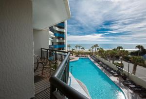 a balcony with a view of a pool and the ocean at Ocean Reef Resort in Myrtle Beach