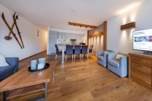 a living room with a couch and a dining room at Residenz Wildkogelbahnen Top 7 in Neukirchen am Großvenediger