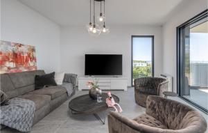 a living room with a couch and chairs and a tv at Nice Apartment In Kostrena With Wifi in Kostrena