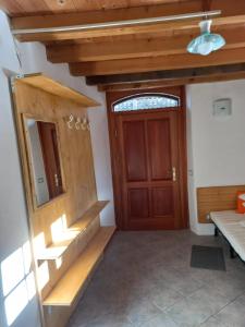 a room with a wooden door and stairs and a mirror at Ala Roda- appartamento in Ziano di Fiemme